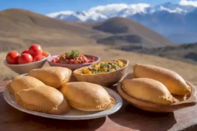 Mesa rústica con platos tradicionales chilenos como empanadas y pastel de choclo