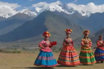 Danzantes en trajes tradicionales andinos bailan frente a montañas