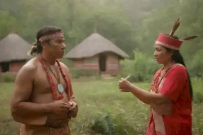 Encuentro cultural entre indígenas en trajes tradicionales y turistas en un paisaje natural vibrante