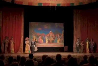 Representación artística que contrasta un set de cine vibrante con un escenario de teatro tradicional